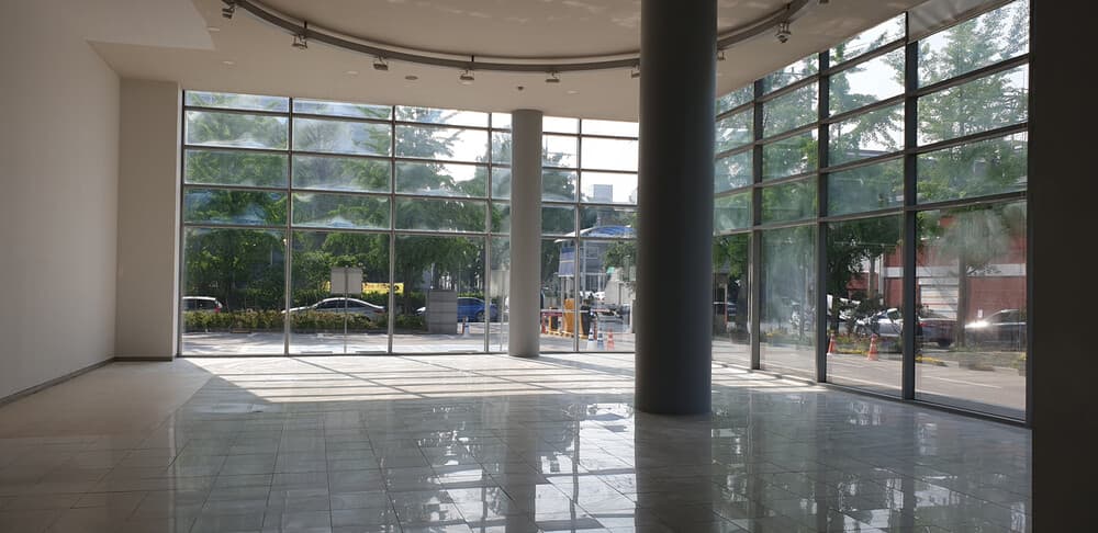 Inside the SFACTORY glass house — a bright event space surrounded by floor-to-ceiling windows