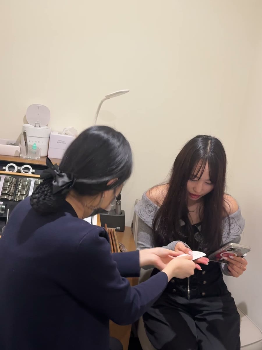 직원이 서류를 짚어 가며 환자에게 검사 내용을 설명하는 모습.